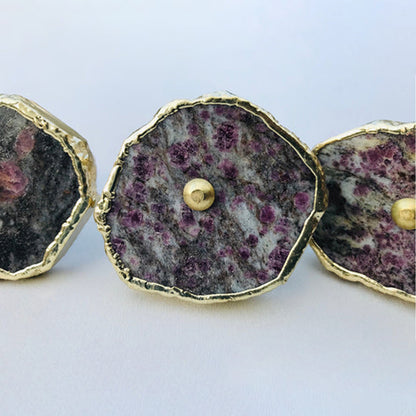 Lepidolite slice knob centered in a row, dense lilac speckles and a brass pin