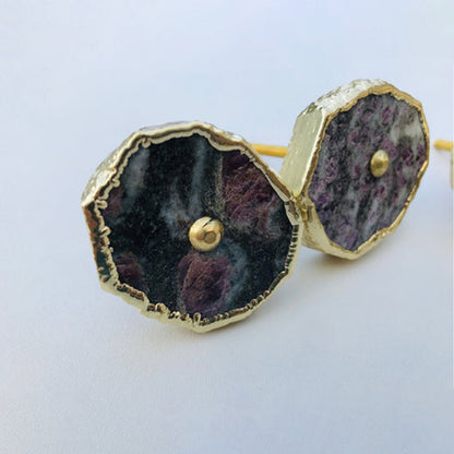 Two round lepidolite slice cabinet knobs in purple and gray with gilded rims