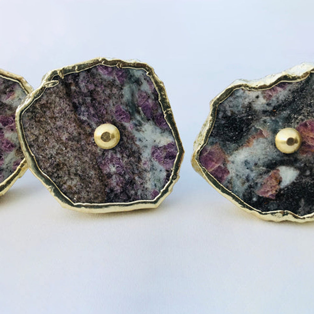 Close-up of lepidolite slice knobs, purple flecks on black and white stone