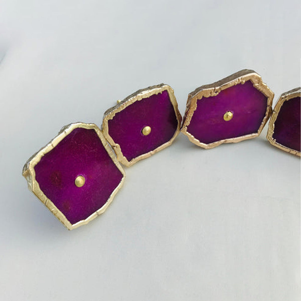 Closer view of magenta agate slice knobs in an arc, the nearest one at left