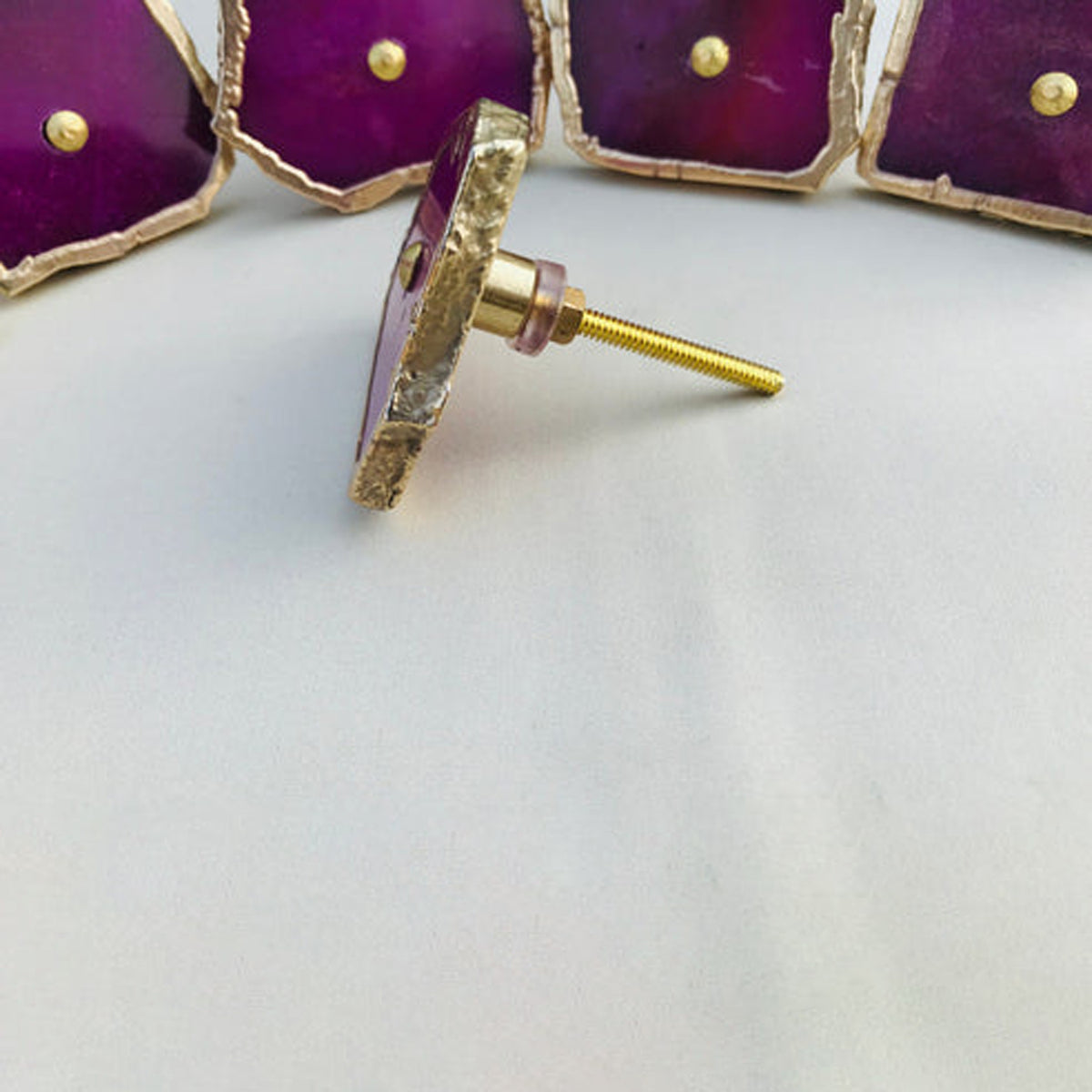Magenta agate slice knobs, one turned to show its bolt