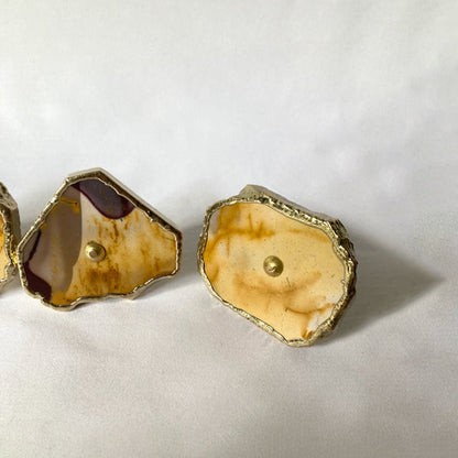 Two mookaite slice knobs, one with a deep red edge, seen low