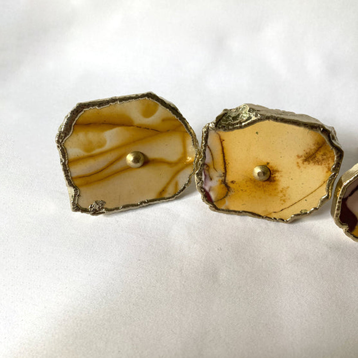 Two mookaite slice knobs side by side, ochre swirls on cream