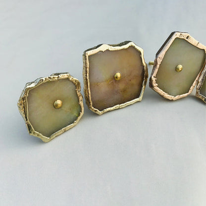 Three mustard agate slice knobs, the middle one with a brownish tint