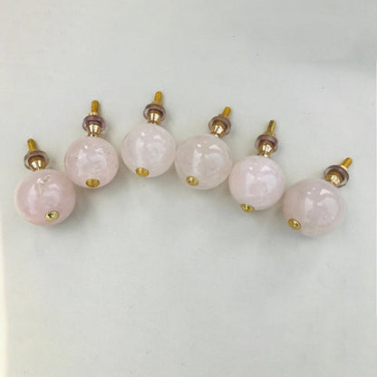Rose quartz sphere knobs in an arc, bolts pointing up behind them