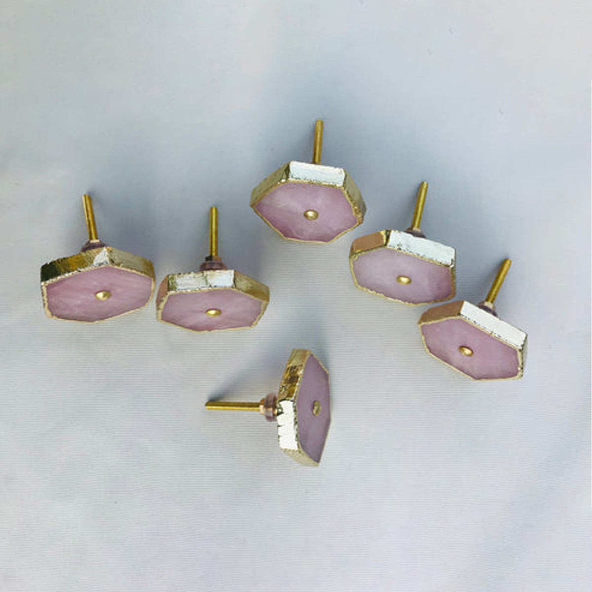 Rose quartz hexagon knobs seen from above with their bolts sticking up