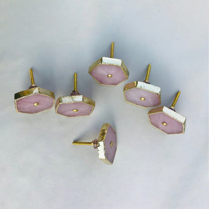 Rose quartz hexagon knobs seen from above with their bolts sticking up
