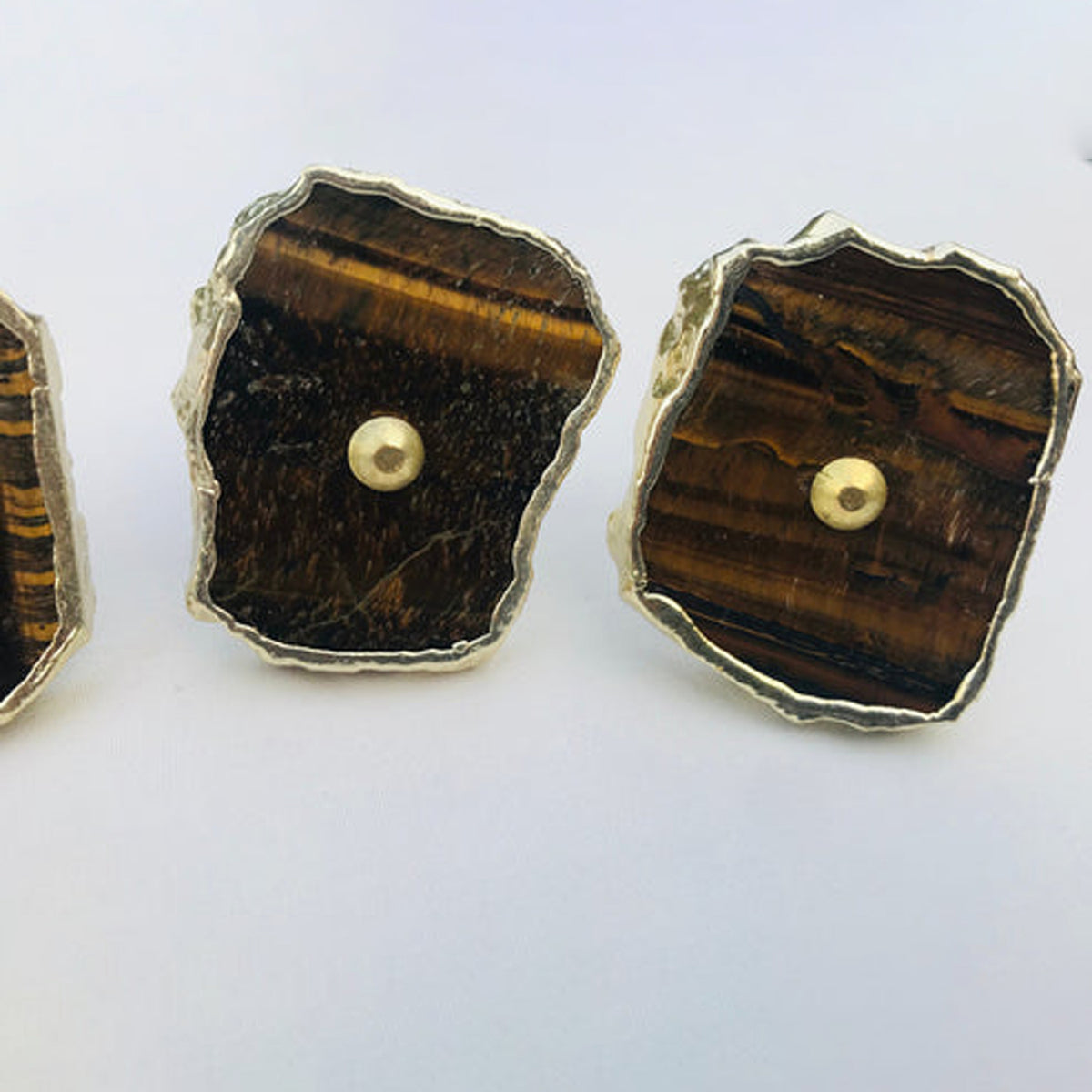 Two tiger agate slice knobs up close, one with rough dark streaks
