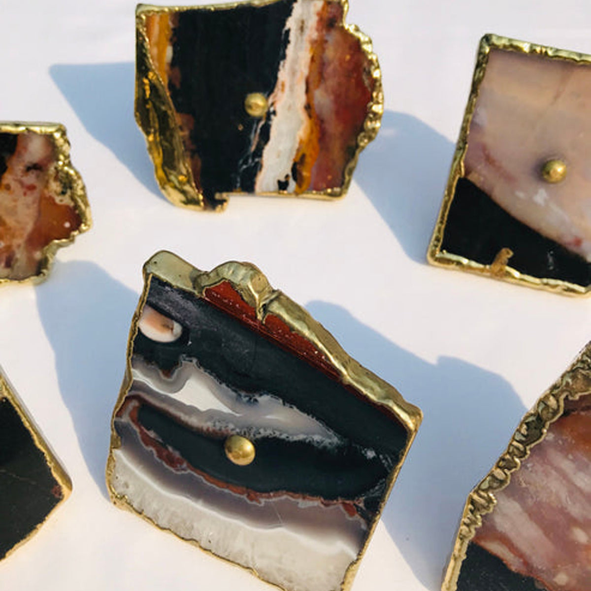 Close-up of a zebra agate slice knob with black, brown and white bands and a center pin