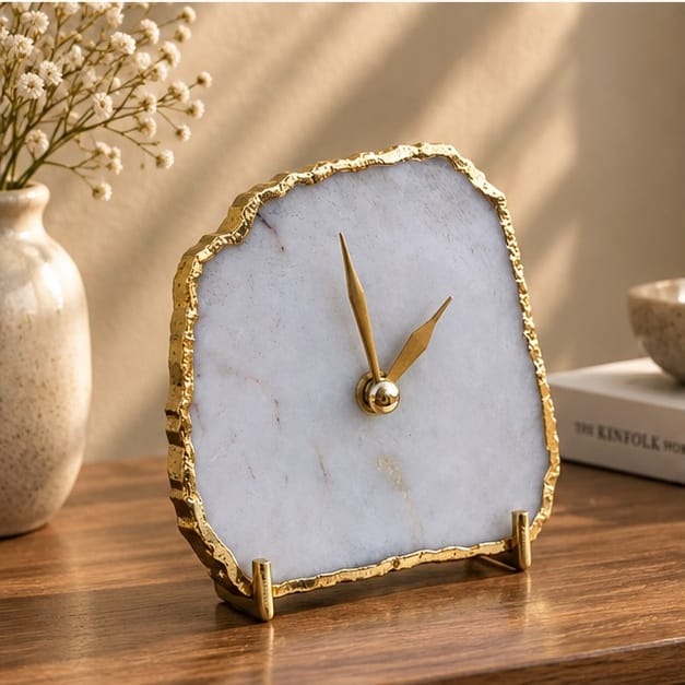 White agate desk clock on a wooden table with dried flowers