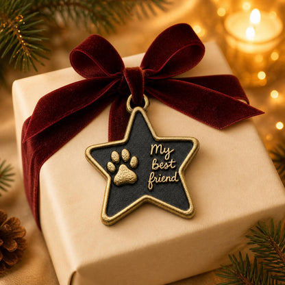 Star paw print ornament hanging on a box wrapped in kraft paper with a red velvet bow