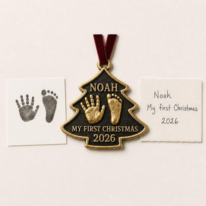 An antique brass tree-shaped baby ornament with a raised handprint and footprint