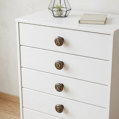 Initial knobs reading A, D, K and T on a white chest of drawers