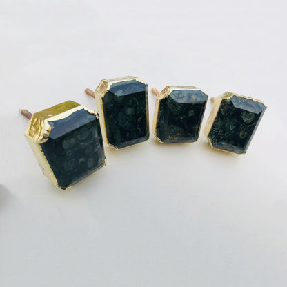 Four rectangular faceted hematite cabinet knobs in gilded collars