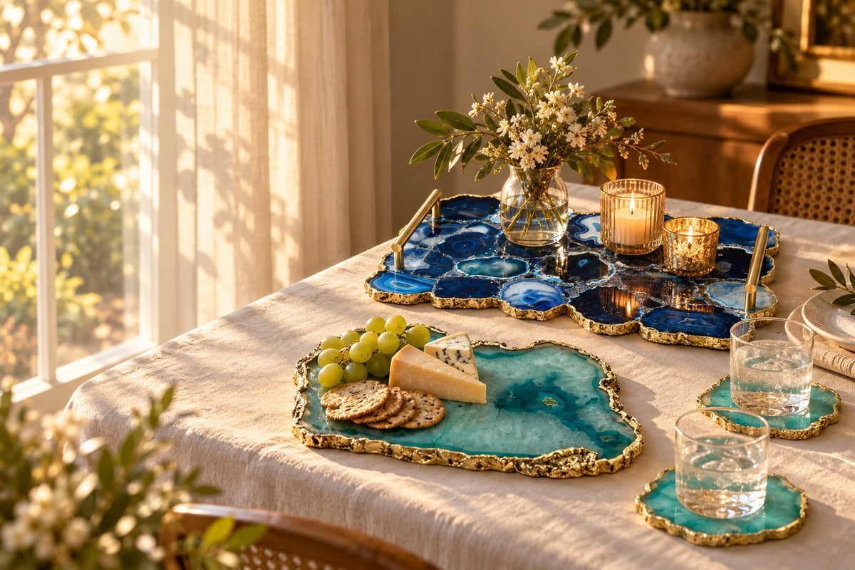 Blue agate serving tray with brass handles, an aqua agate cheese board with crackers, grapes and cheese, and agate coasters on a sunlit dining table